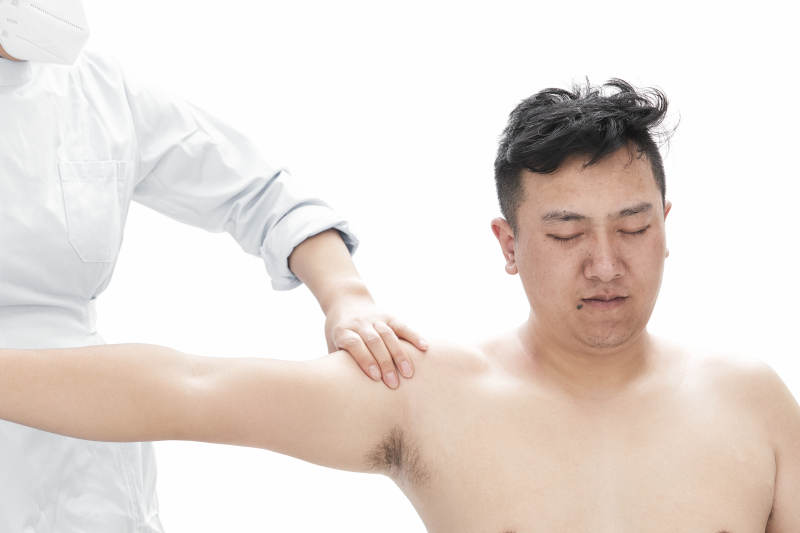 专业按摩师为男子进行身体按摩