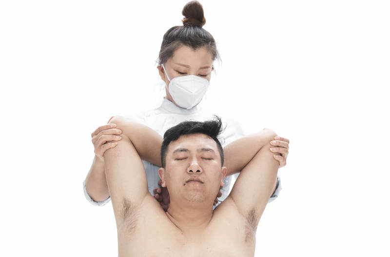 专业按摩师为男子进行身体按摩