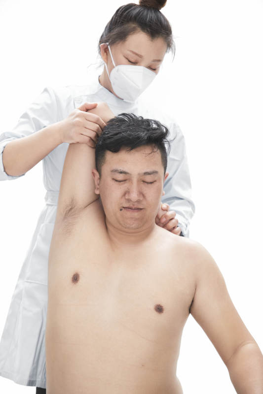 专业按摩师为男子进行身体按摩