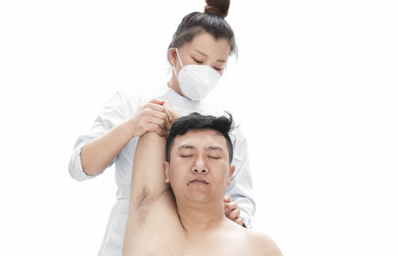 专业按摩师为男子进行身体按摩