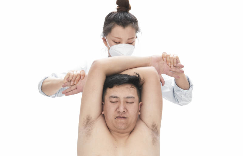 專業(yè)按摩師為男子進(jìn)行身體按摩