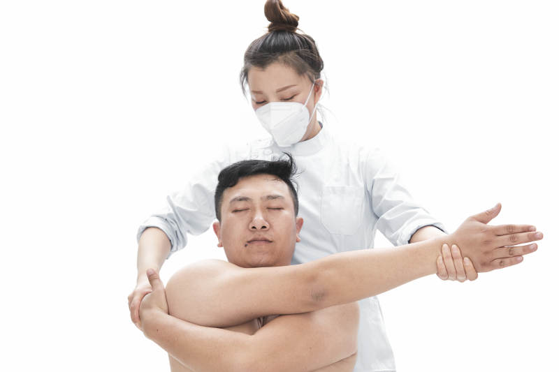 专业按摩师为男子进行身体按摩