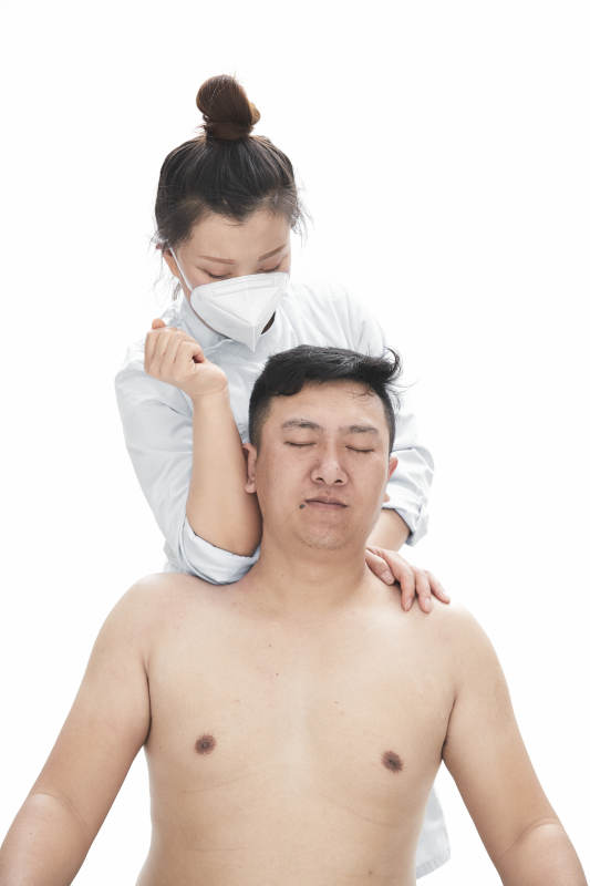 专业按摩师为男子进行身体按摩