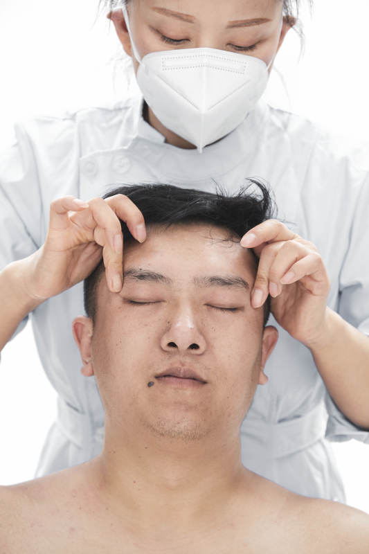 专业按摩师为男子进行身体按摩