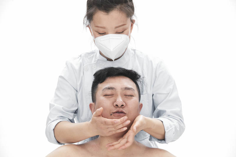 专业按摩师为男子进行身体按摩