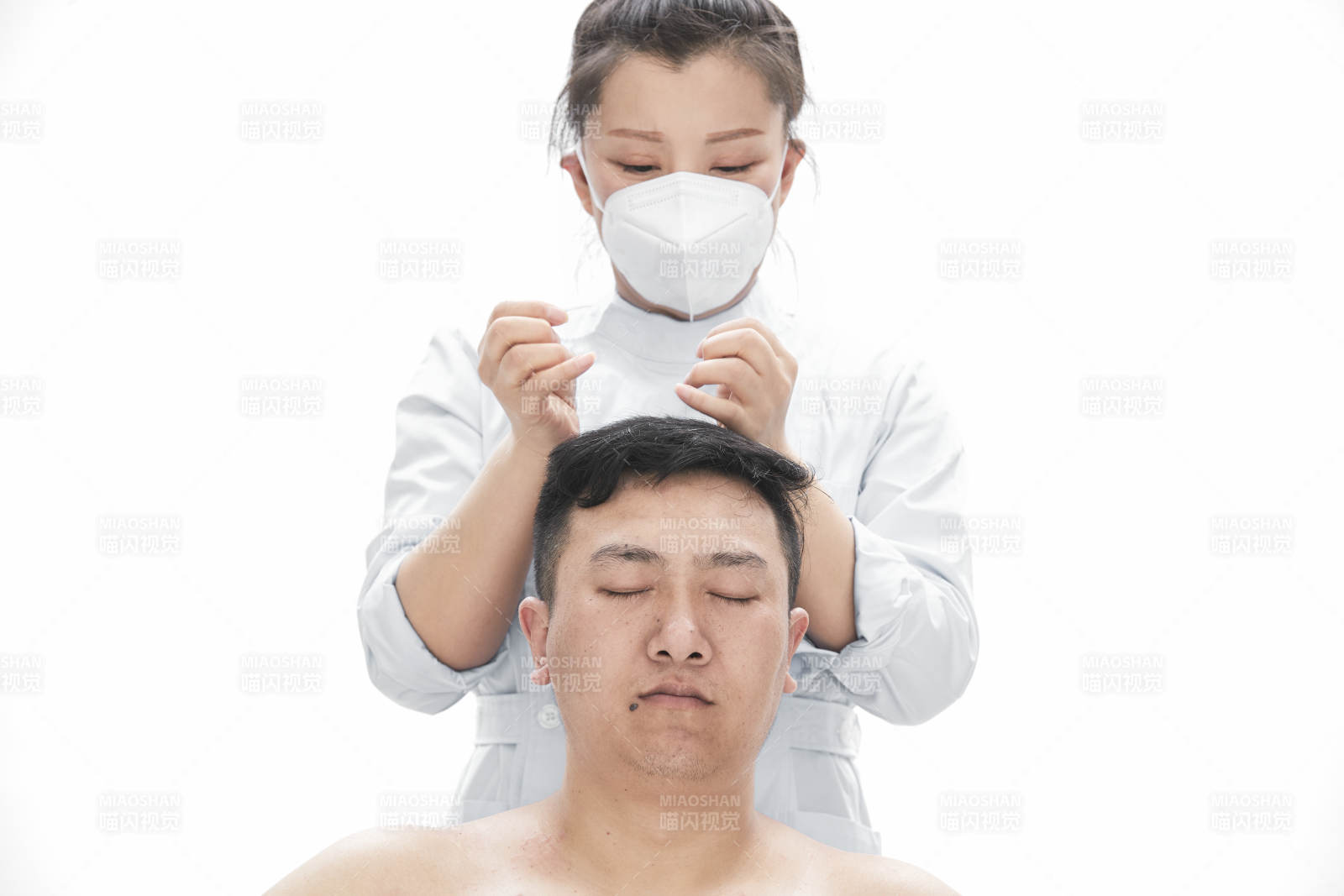 专业按摩师为男子进行身体按摩