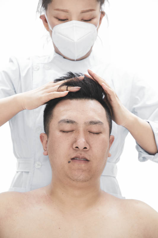 专业按摩师为男子进行身体按摩