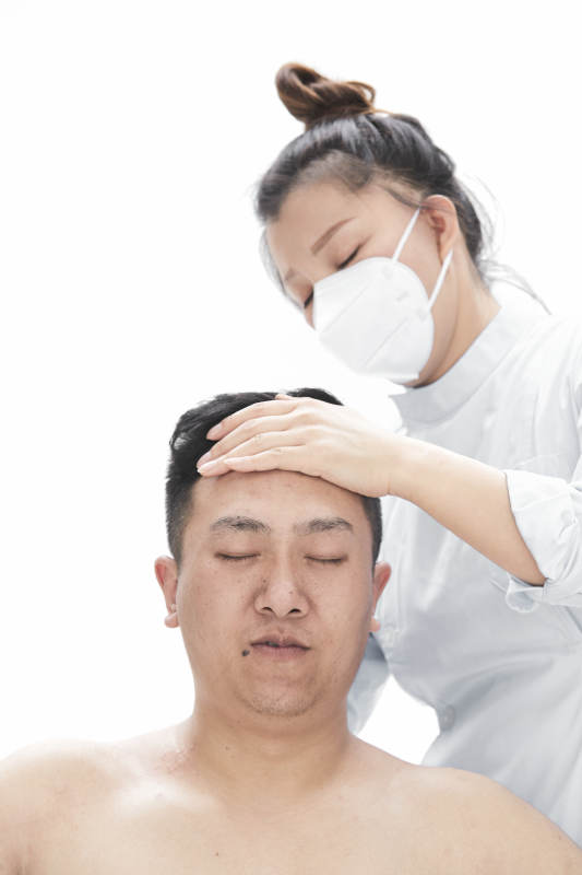 专业按摩师为男子进行身体按摩