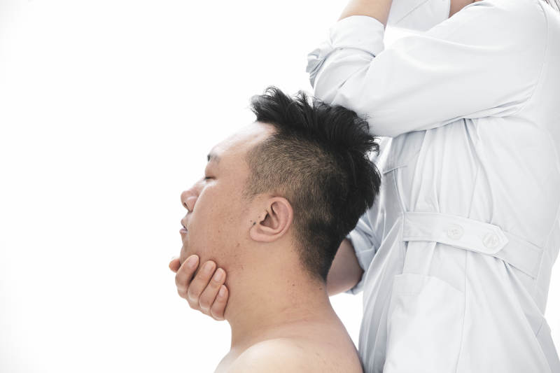 专业按摩师为男子进行身体按摩