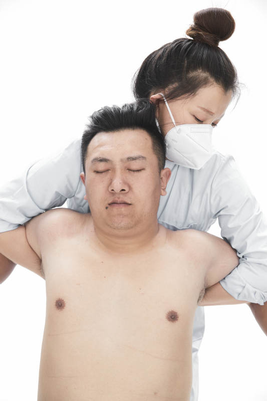 专业按摩师为男子进行身体按摩