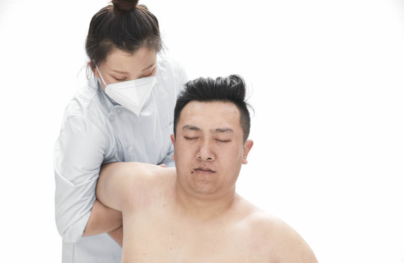 专业按摩师为男子进行身体按摩