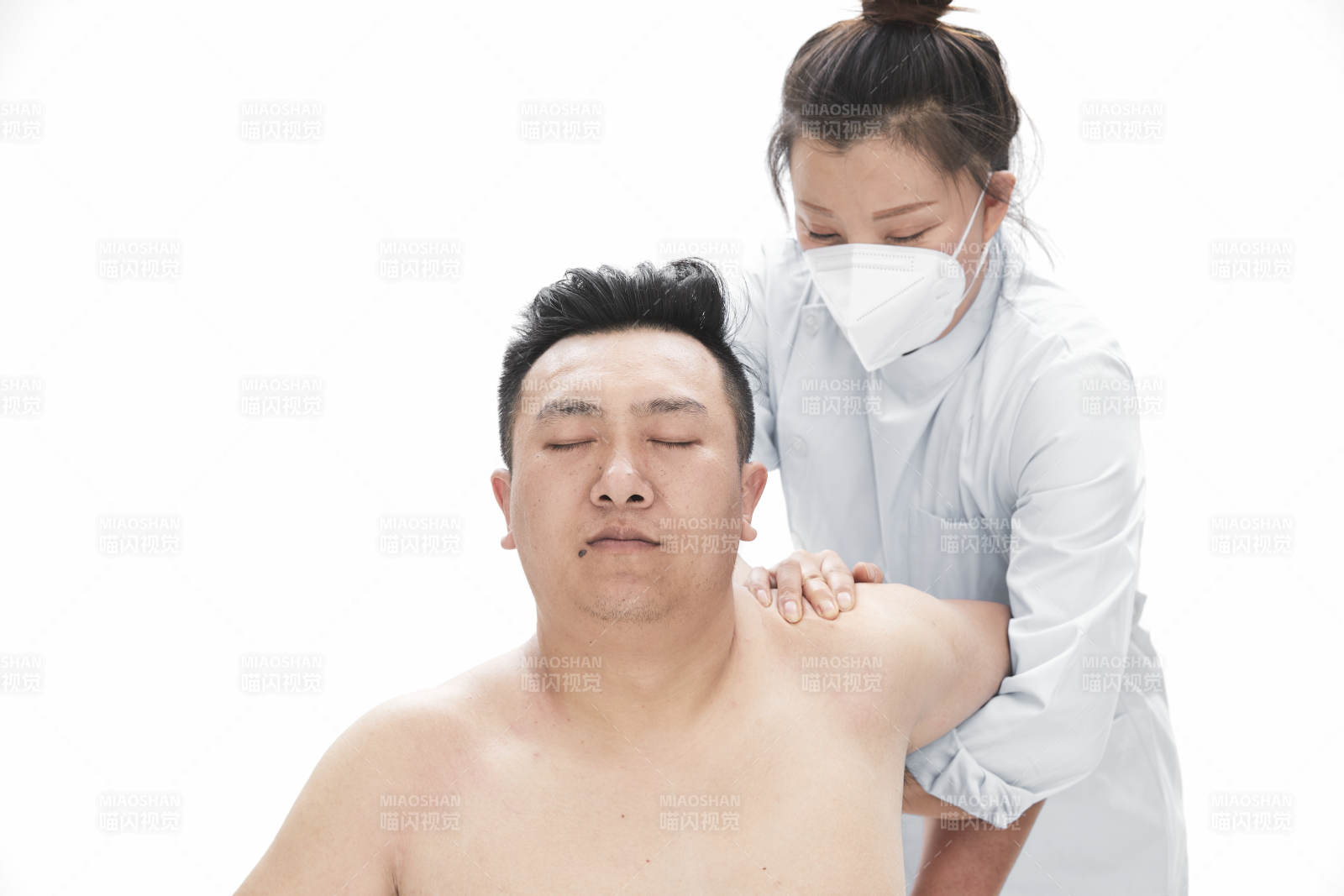 专业按摩师为男子进行身体按摩