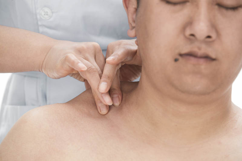专业按摩师为男子进行肩部按摩