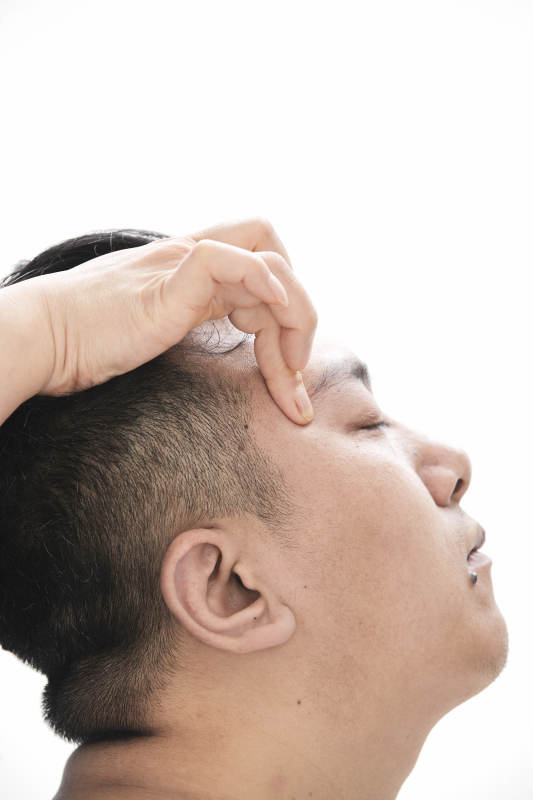 专业按摩师为男子进行头部按摩