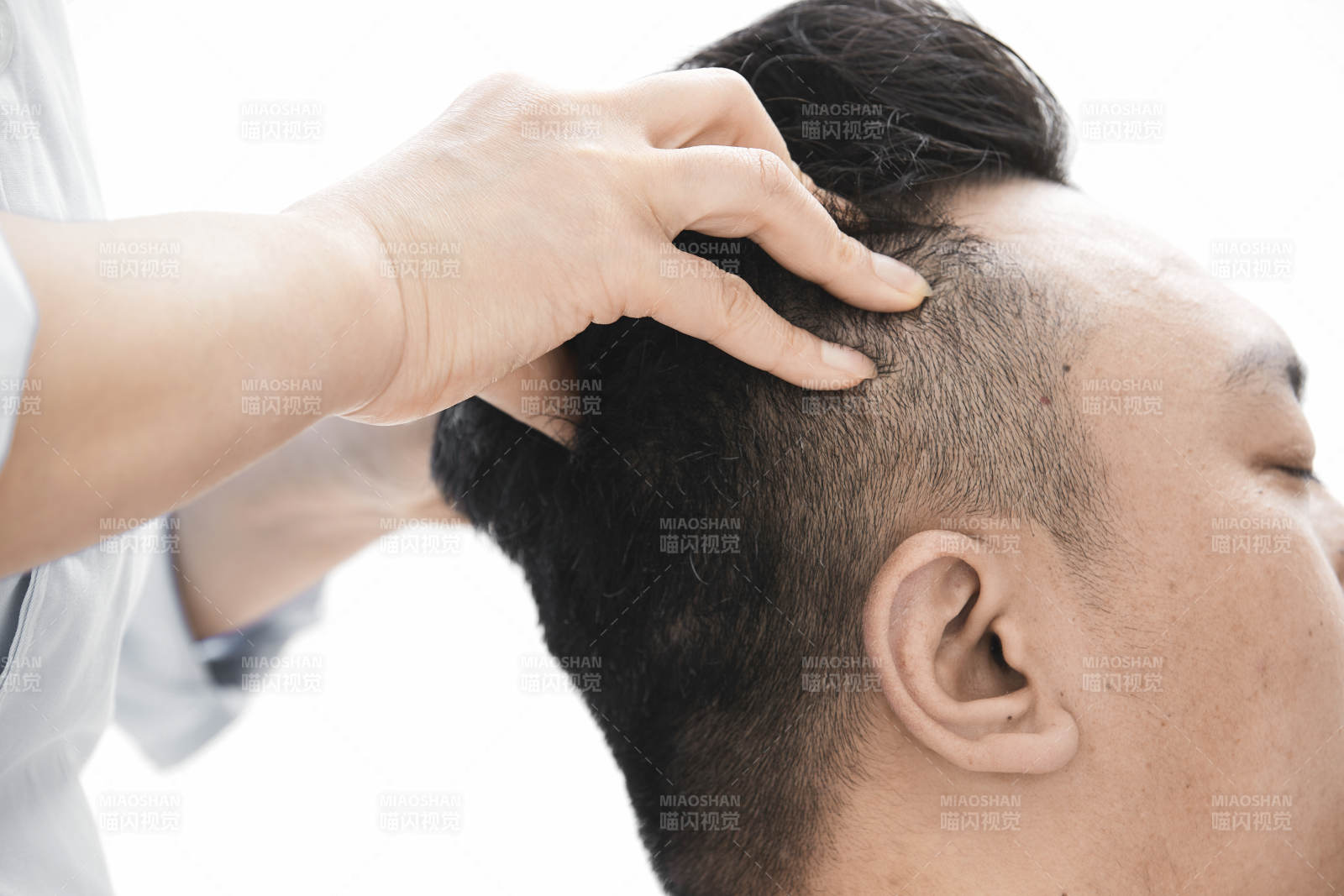 专业按摩师为男子进行头部按摩