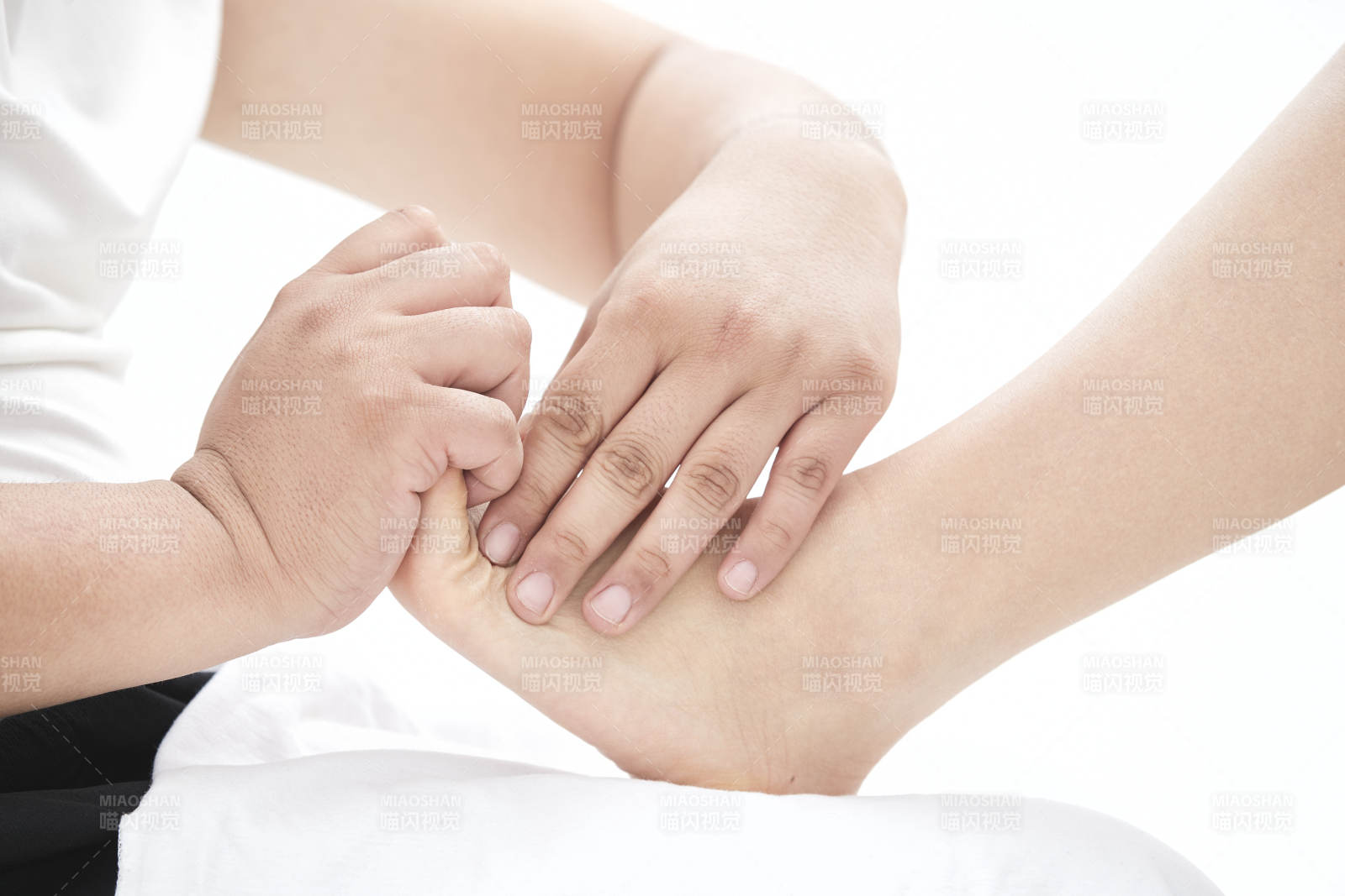 在白色背景上穿著黑色長襪的女人的苗條的腿