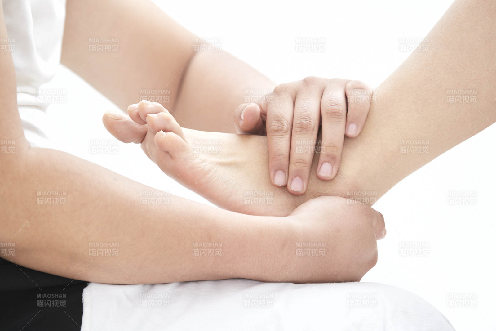 在白色背景上穿着黑色长袜的女人的苗条的腿