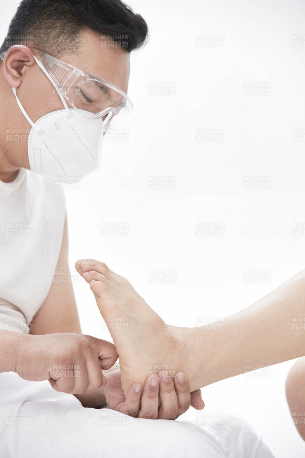 在白色背景上穿著黑色長(zhǎng)襪的女人的苗條的腿