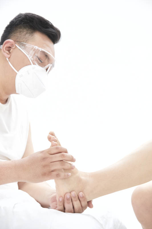 在白色背景上穿着黑色长袜的女人的苗条的腿