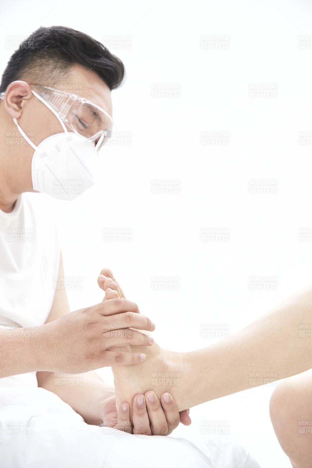 在白色背景上穿着黑色长袜的女人的苗条的腿