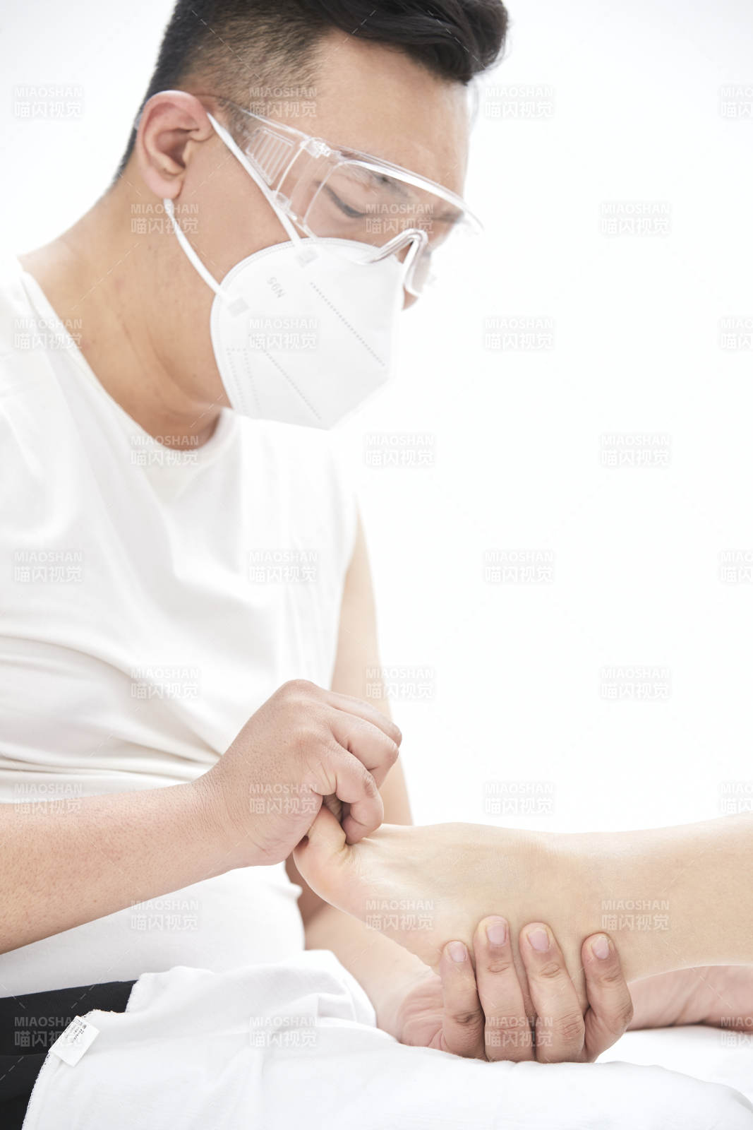 在白色背景上穿著黑色長襪的女人的苗條的腿