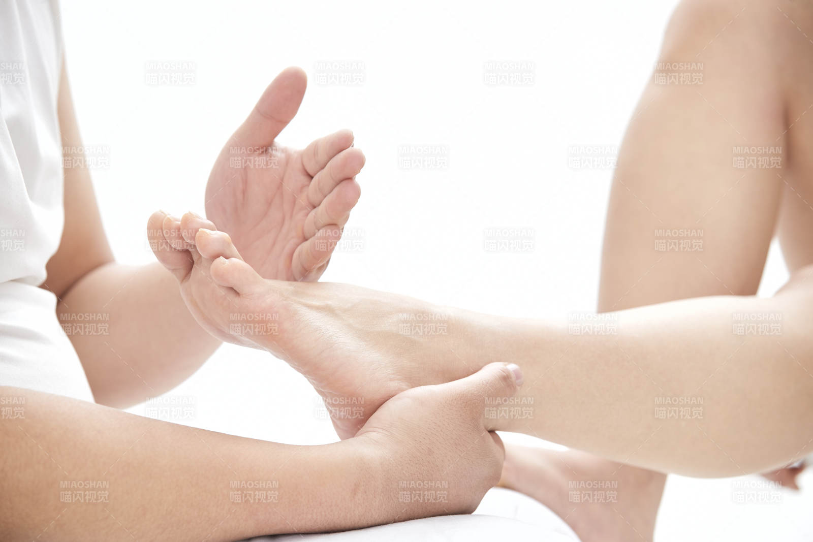 在白色背景上穿著黑色長襪的女人的苗條的腿