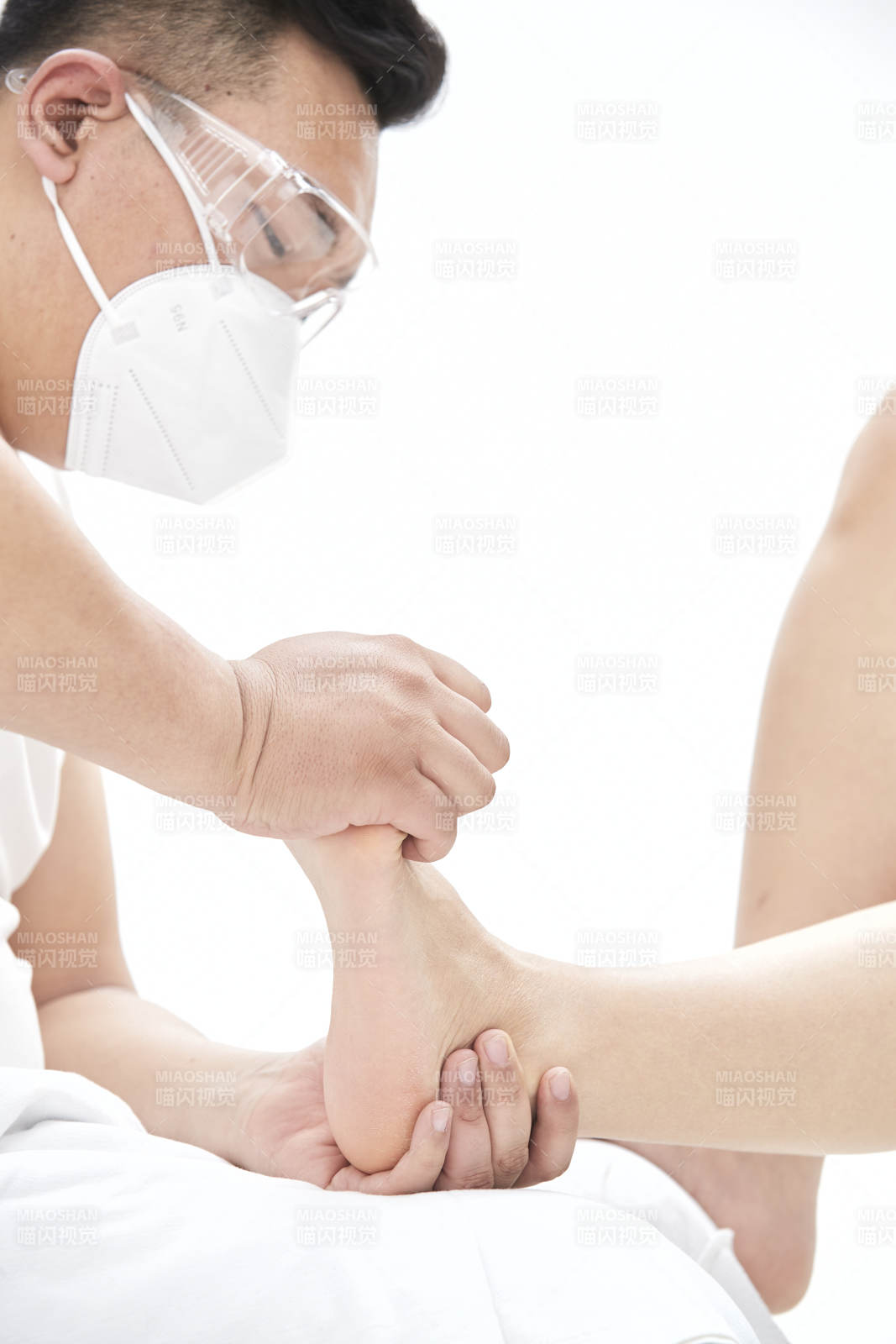 在白色背景上穿着黑色长袜的女人的苗条的腿