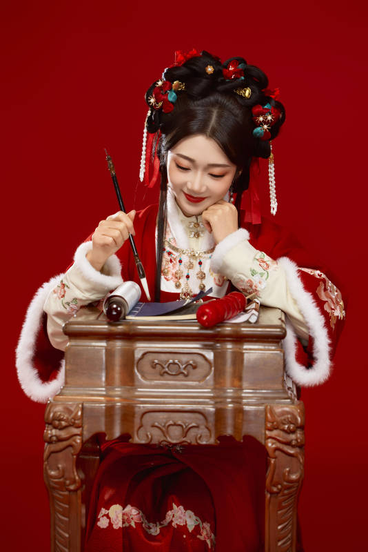 红色背景下身穿喜庆汉服认真学习的中国美女