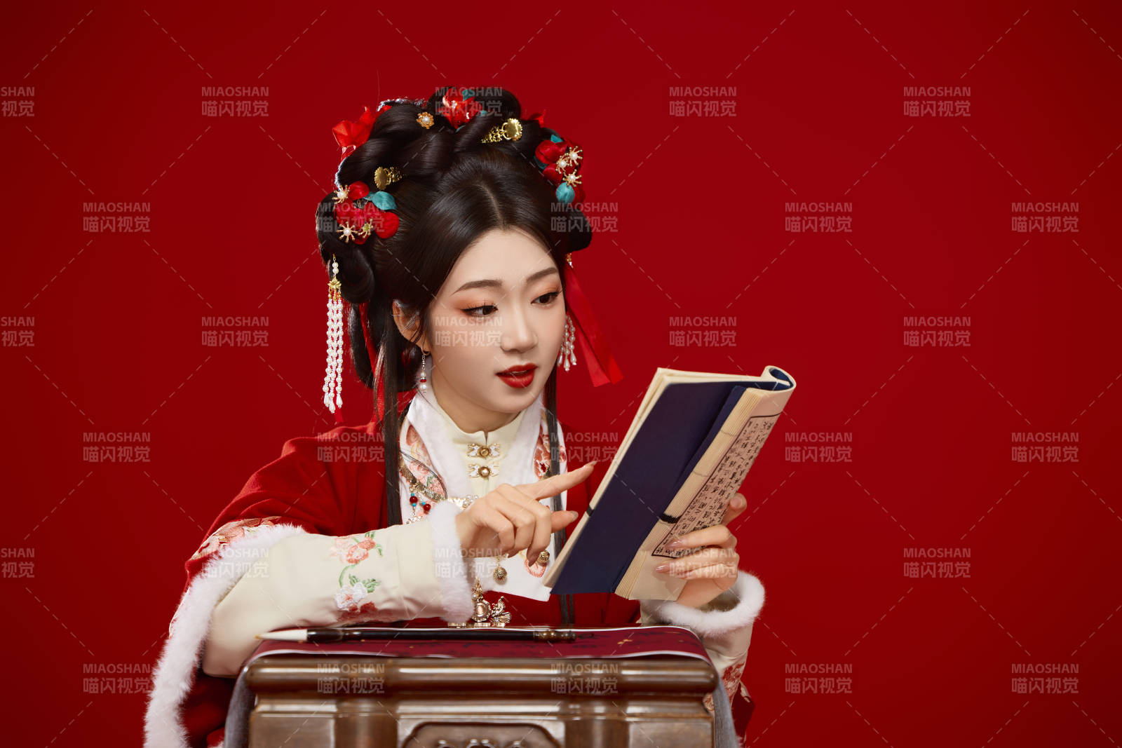 红色背景下身穿喜庆汉服认真学习的中国美女