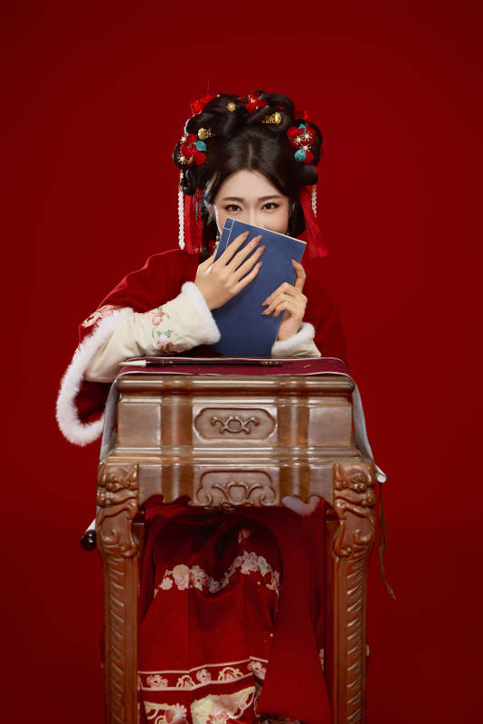 红色背景下身穿喜庆汉服认真学习的中国美女