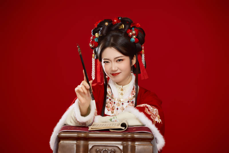 红色背景下身穿喜庆汉服认真学习的中国美女