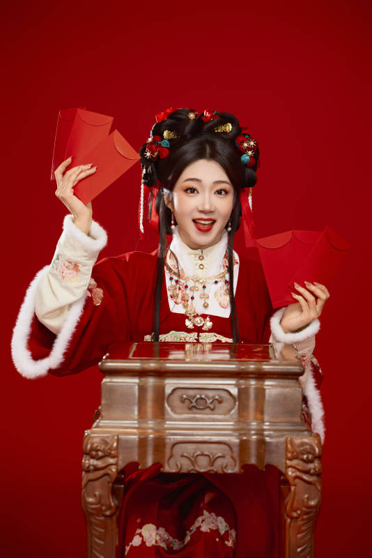红色背景下身穿汉服手拿红包拜年的中国美女