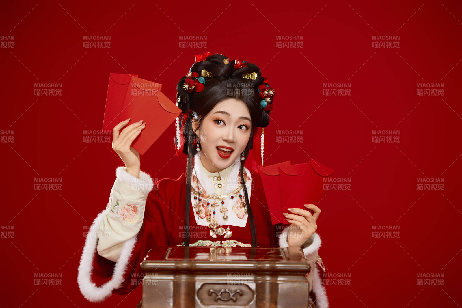 紅色背景下身穿漢服手拿紅包拜年的中國美女