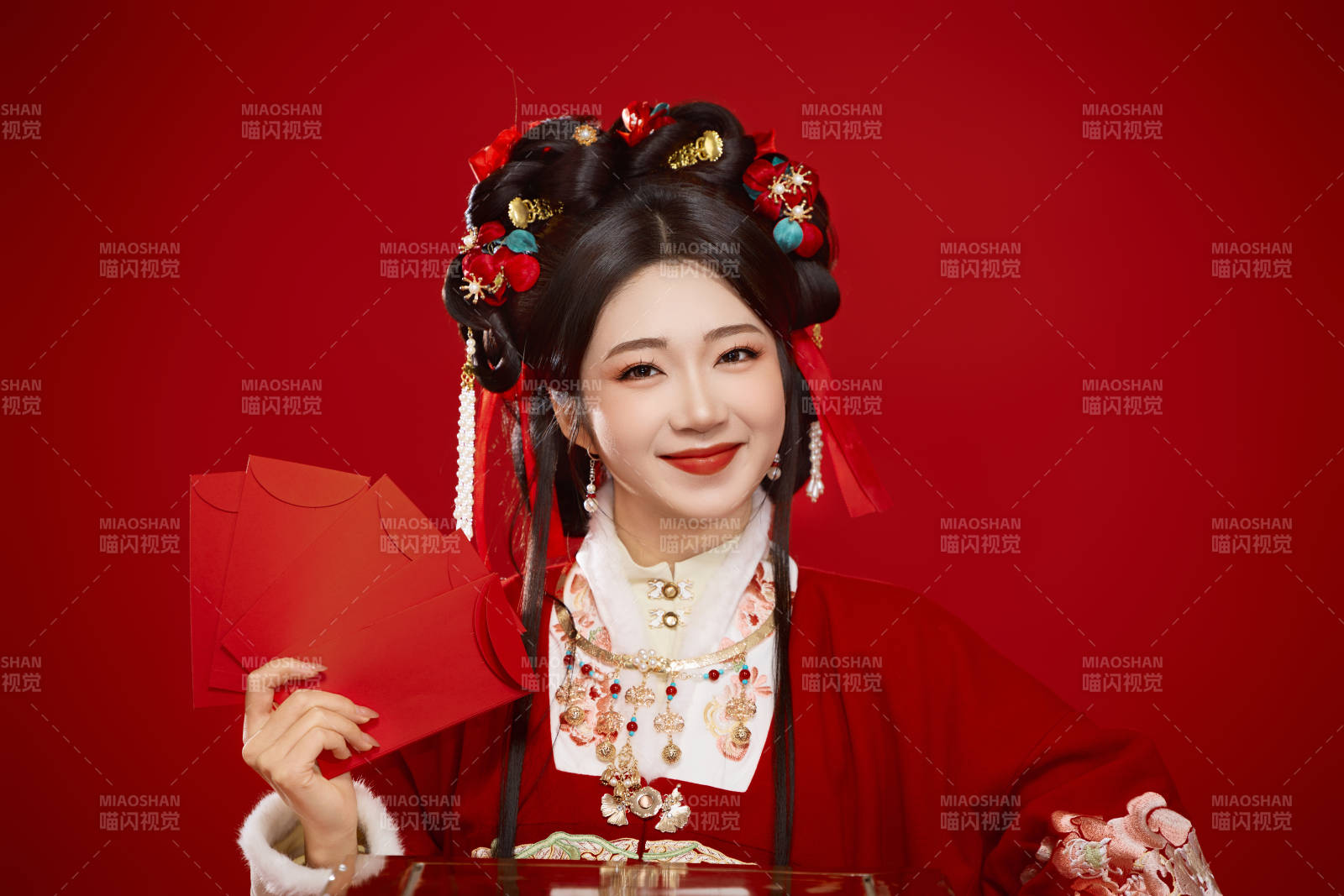 红色背景下身穿汉服手拿红包拜年的中国美女