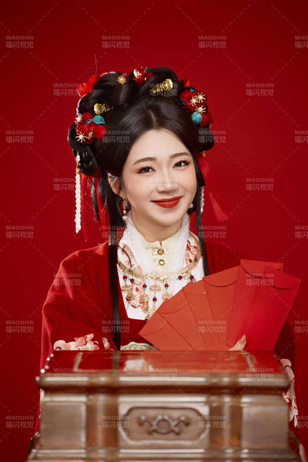 红色背景下身穿汉服手拿红包拜年的中国美女