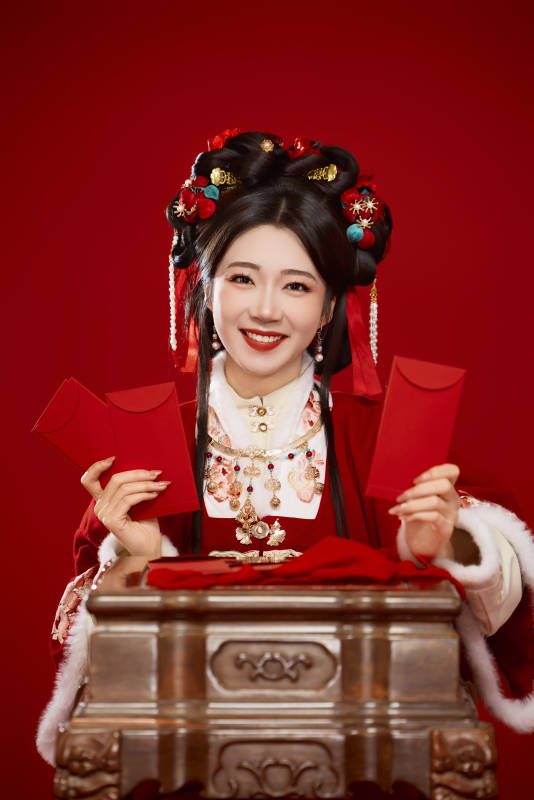 红色背景下身穿汉服手拿红包拜年的中国美女