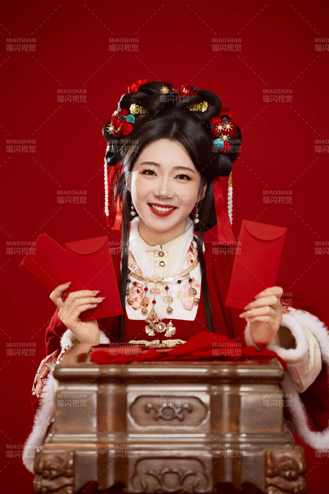 红色背景下身穿汉服手拿红包拜年的中国美女