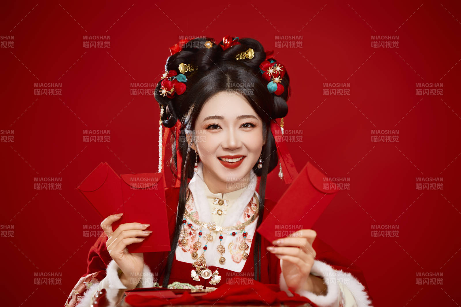 红色背景下身穿汉服手拿红包拜年的中国美女