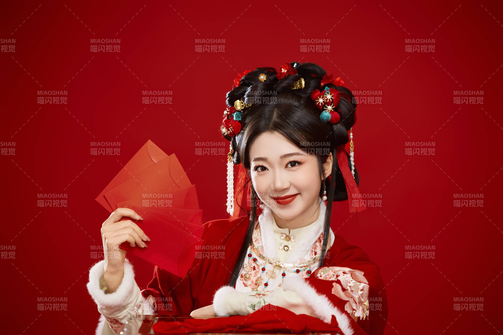 红色背景下身穿汉服手拿红包拜年的中国美女