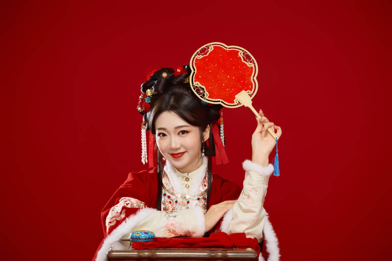 喜庆红色背景下身穿中国汉服的年轻女性