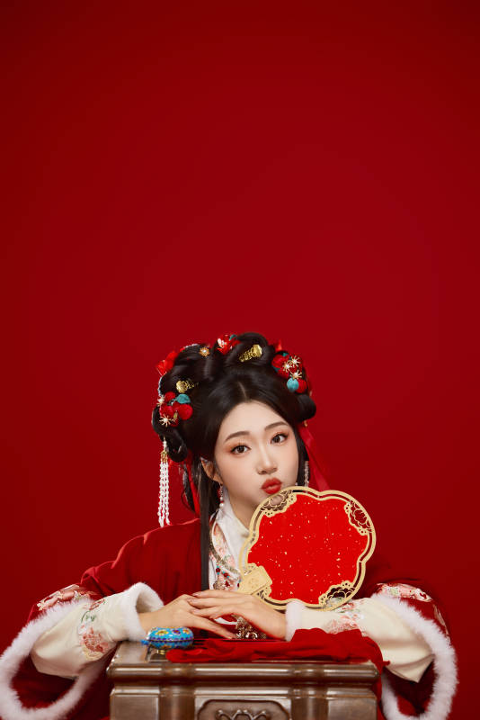 喜庆红色背景下身穿中国汉服的年轻女性