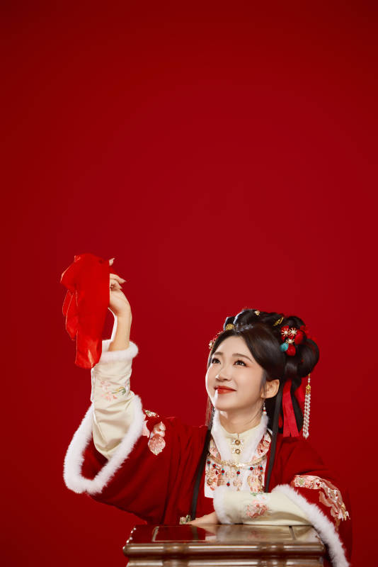 喜庆红色背景下身穿中国汉服的年轻女性
