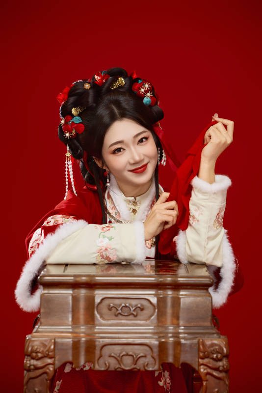 喜庆红色背景下身穿中国汉服的年轻女性