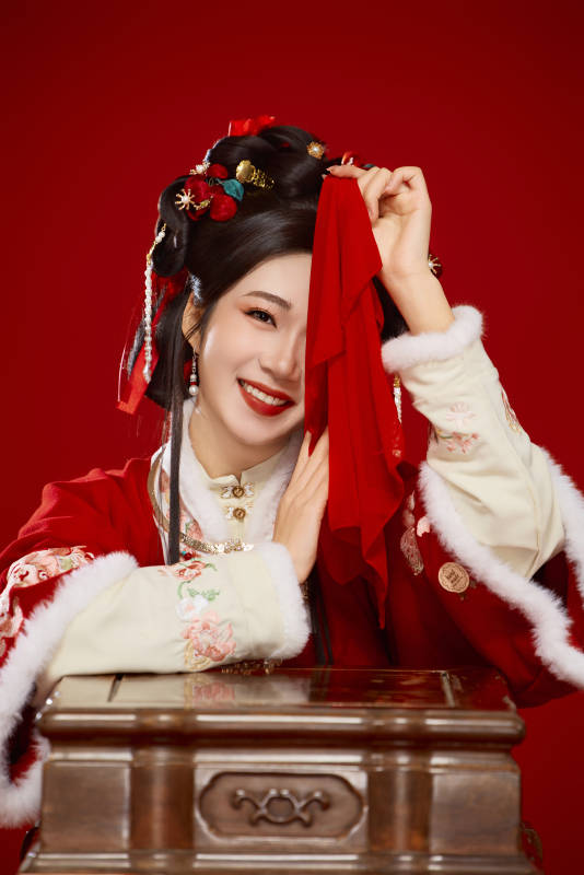 喜庆红色背景下身穿中国汉服的年轻女性