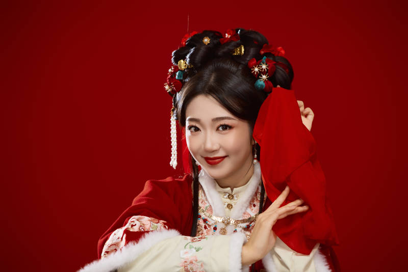 喜庆红色背景下身穿中国汉服的年轻女性