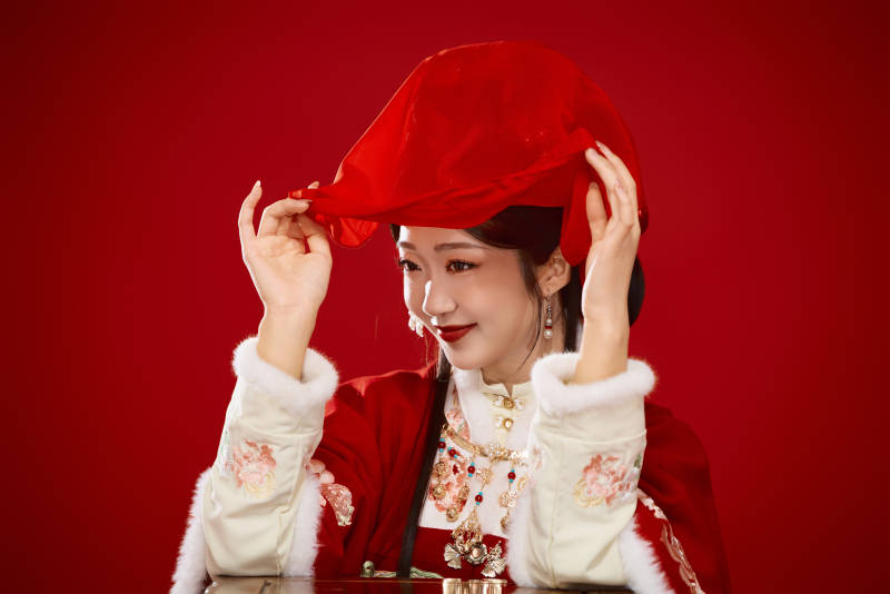 喜庆红色背景下身穿中国汉服的年轻女性