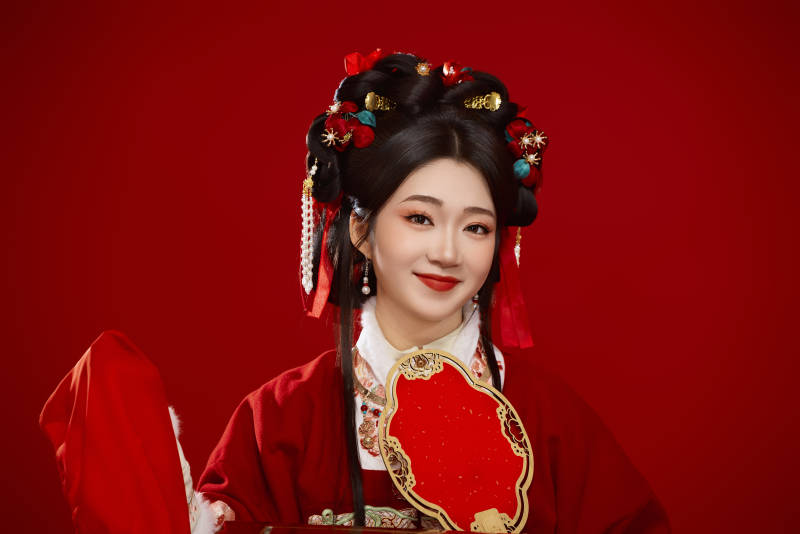 喜庆红色背景下身穿中国汉服的年轻女性