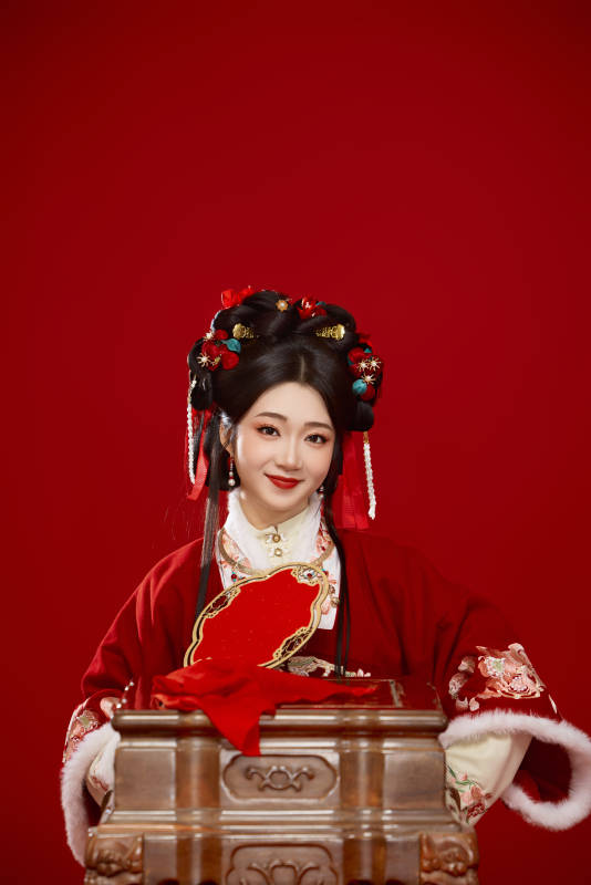 喜庆红色背景下身穿中国汉服的年轻女性