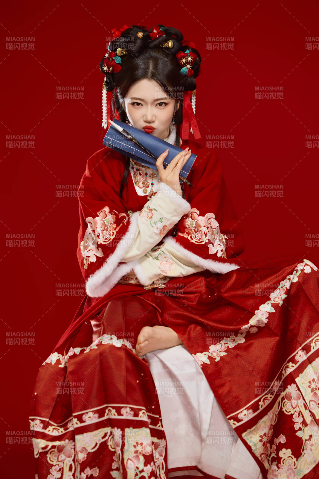 紅色背景下身穿喜慶漢服認真學習的中國美女