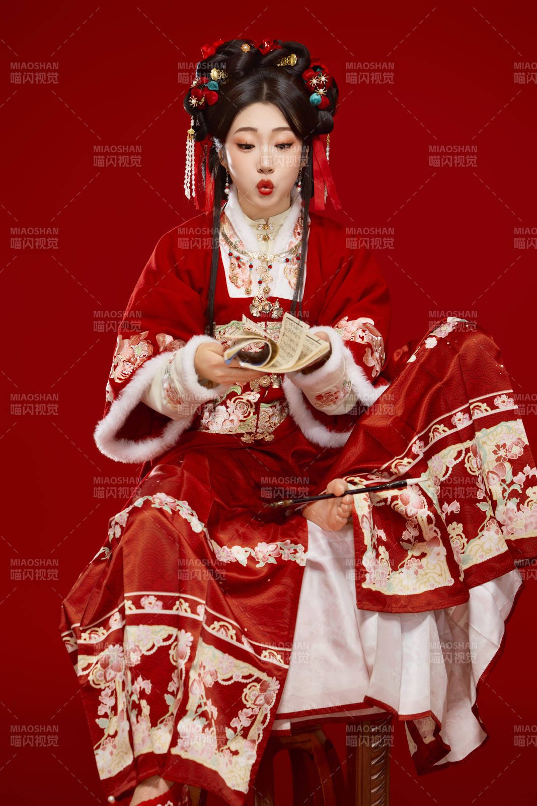 紅色背景下身穿喜慶漢服認真學習的中國美女
